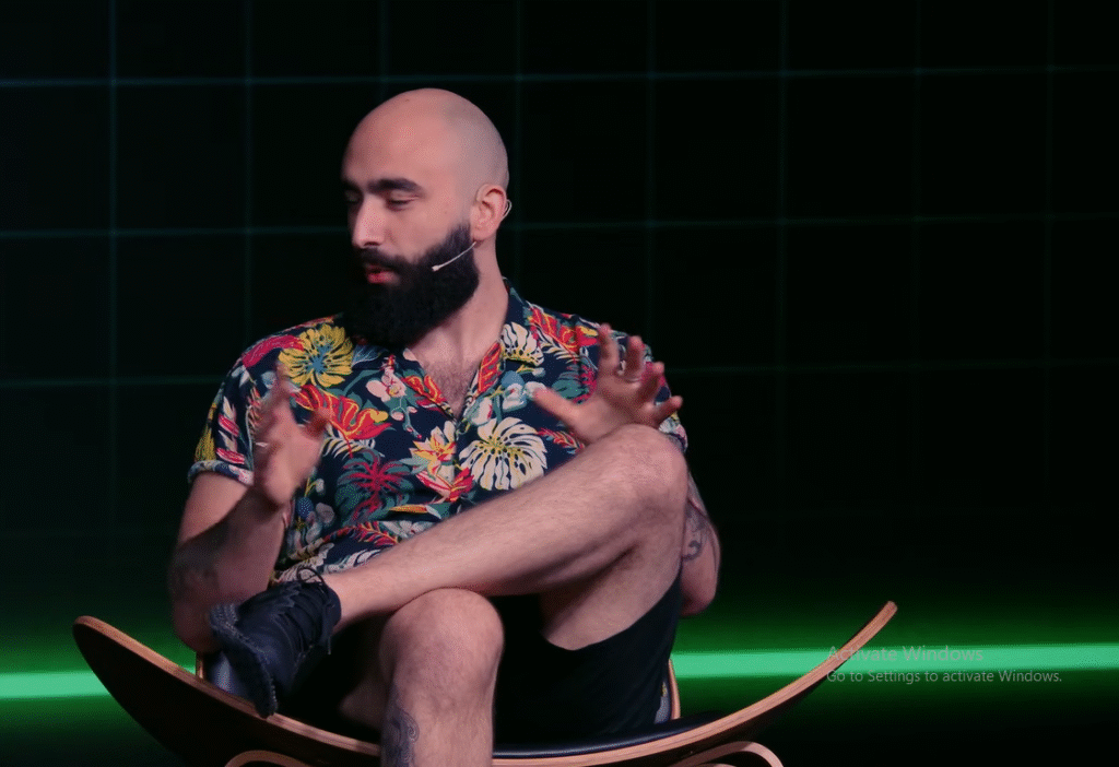 Mert Mumtaz smiling at a crypto event, symbolizing his journey from tech education to becoming a well-known crypto influencer.